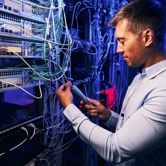 Focused data center employee checking cabling infrastructure